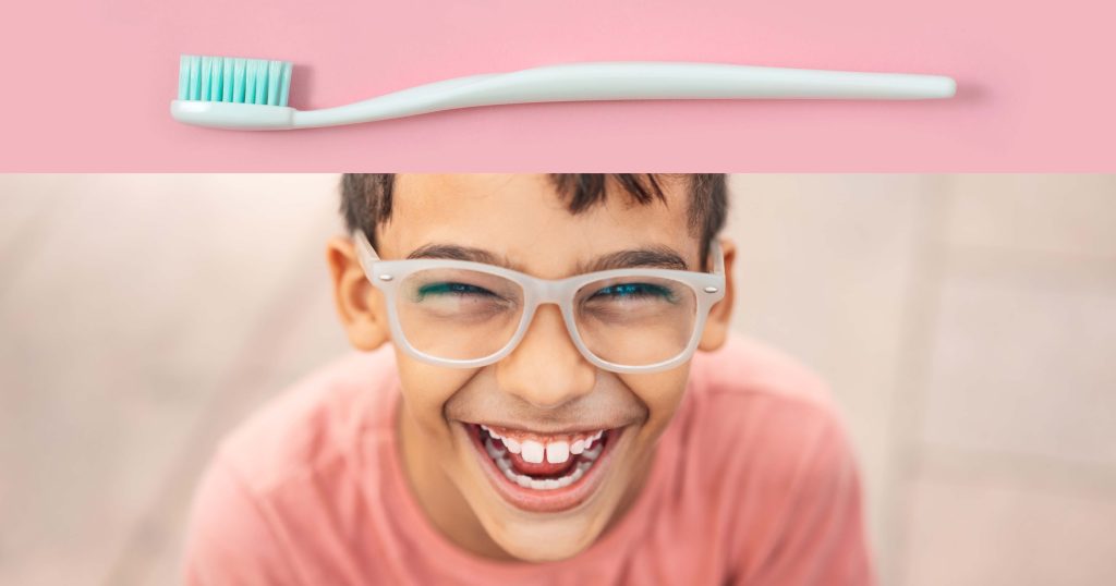 Image of boy with glasses, smiling.