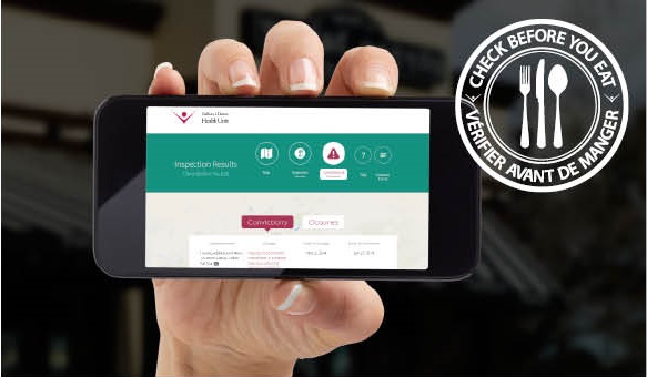 hand holding mobile phone showing "check before your eat" website