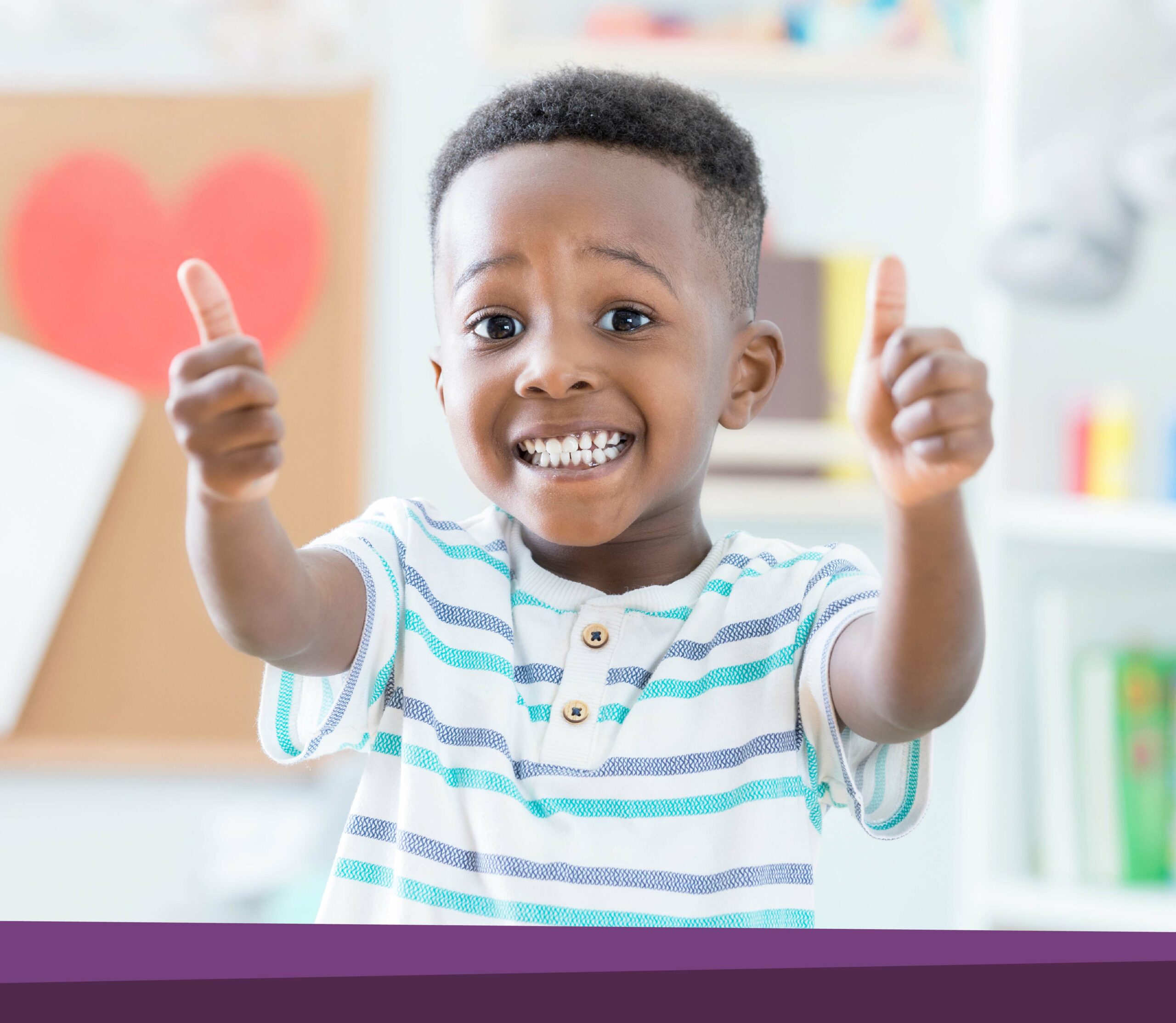 Little boy gives two thumbs at daycare.